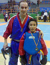 Uno de los campeones posa con la medalla junto a su entrenador