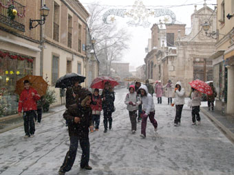 Escolares juegan con la nieve ayer, en la calle Almirante.